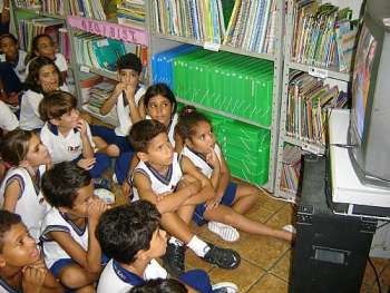 Crianças assistem vídeo com as histórias de Monteiro Lobato