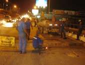 Homens trabalham nas placas de metal da ponte da Avenida Afrânio Lages
