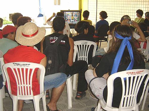 Os participantes participam de mesas de jogos para iniciantes, debates e palestras.
