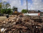 Trator recolhe destroços da demolição na praça central do Colina