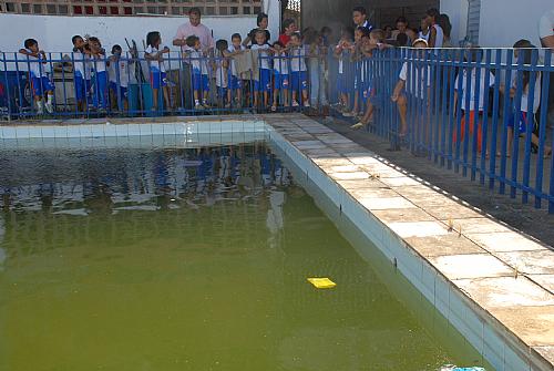 Crianças observam piscina que não pode ser utilizada