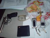 Dinheiro, arma e objetos encontrados com os acusados