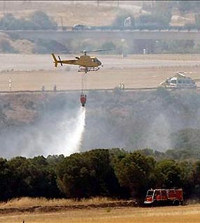 Helicóptero despeja água sobre avião acidentado no aeroporto de Madri
