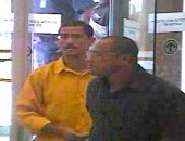 Os assaltantes - um de camisa amarela e manga cumprida, usando óculos e de bigode,