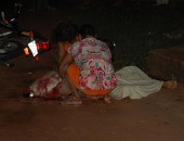 Mãe e irmã abraçam a vítima em meio a chuva.