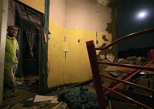 Homem observa na madruga deste domingo (28) estragos provocados pelo tremor em sua casa, em bairro de imigrantes peruanos em Santiago do Chile