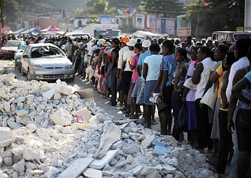 Haitianos formam fila para pegar ajuda humanitária nesta sexta-feira (5) em distrito de Porto Príncipe