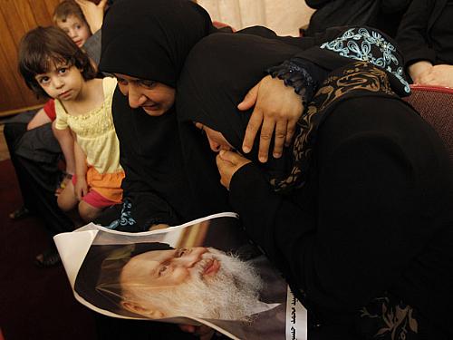 Mulheres lamentam sobre poster do aiatolá Mohammed Hussein Fadlallah, cuja morte foi anunciada neste domingo (4), aos 75 anos