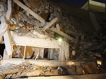 Destroços do prédio destruído no complexo residencial de Muammar Kadhafi, em Trípoli, neste domingo (20), supostamente por um míssil das forças aliadas