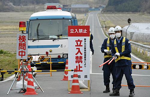 Policiais inspecionam homem em Minamisoma, a cerca de 20km da usina de Fukushima