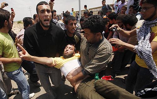 Palestino é carregado após ser ferido em conflito com tropas israelenses em Erez, na fronteira com a Faixa de Gaza