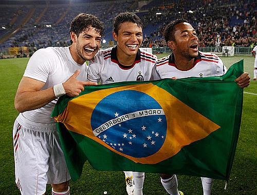 Pato, Thiago Silva e Robinho seguram a bandeira do Brasil durante a comemoração do título
