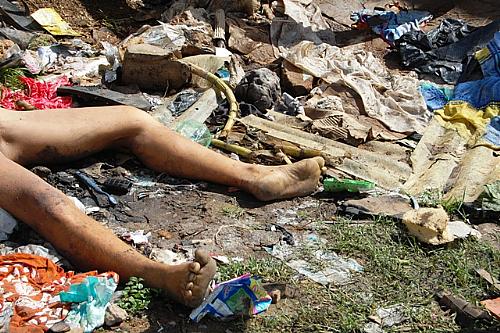Cena triste: corpo de mulher abandonado semidespido em meio ao lixo
