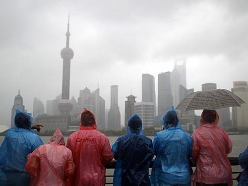 Turistas enfrentaram fortes chuvas e ventos em Xangai, na China, neste domingo