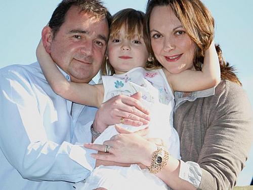Jill Jones (dir.) em foto com a filha, Amelia, e o marido, Martin. Segundo a mulher, ela foi salva pela menina, que "descobriu" um câncer de mama na mãe
