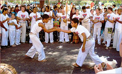 Pessoas lutando capoeira