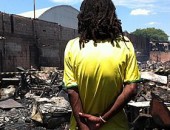 Morador observa destruição em favela que pegou fogo neste domingo
