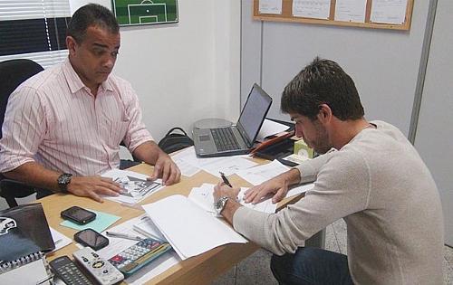 Juninho assinando contrato