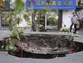 Buraco aberto durante obra de rua em Harbin, na China, nesta terça-feira (14)