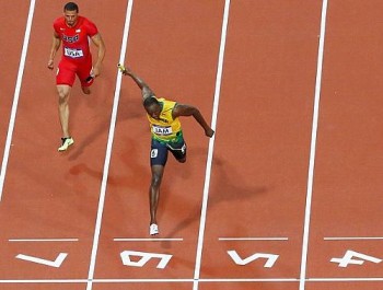Bolt cruza a linha à frente de Ryan Bailey, dos Estados Unidos