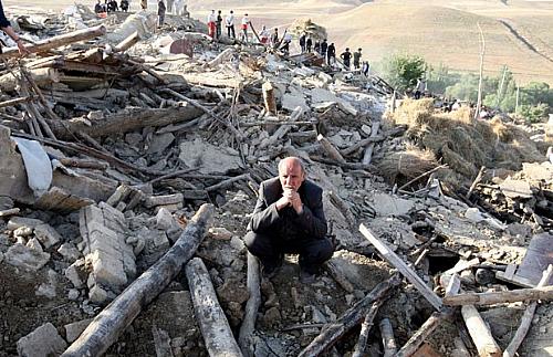 Homem fica no meio de destroços de casa destruída na vila de Baje-Baj, no Irã