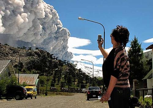 Mulher fotografa fumaça do vulcão Copahue em Caviahue, Argentina, neste sábado (22)
