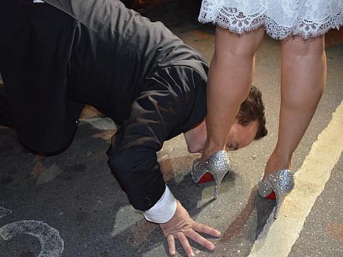 Diante de fotógrafos, Cachoeira repetiu gesto feito durante a cerimônia fechada e beijou os pés da noiva