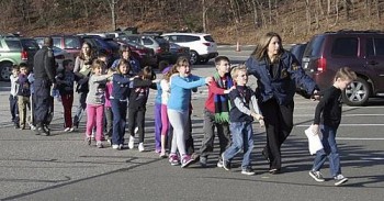 Foto de jornal local mostra crianças sendo retiradas da escola em Newtown, Connecticuc, em que ocorreu o tiroteio nesta sexta-feira