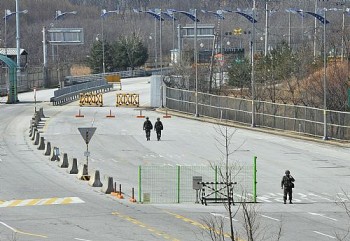 Soldados sul-coreanos caminham em estrada vazia onde normalmente trafegam vários caminhões diariamente. Fronteira foi fechada e acesso de trabalhadores, impedido.