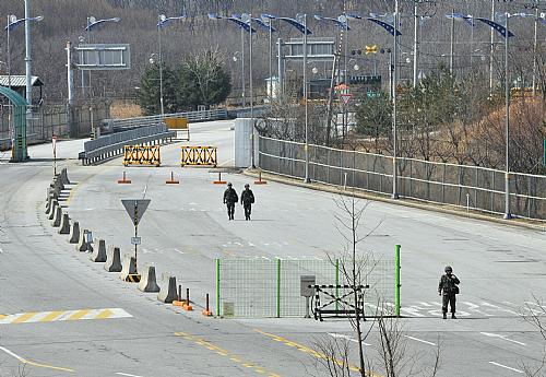 Soldados sul-coreanos caminham em estrada vazia onde normalmente trafegam vários caminhões diariamente. Fronteira foi fechada e acesso de trabalhadores, impedido.