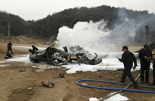 Bombeiros tentam extinguir fogo em helicóptero americano que caiu em Chulwon, na Coreia do Sul, nesta terça-feira (16)