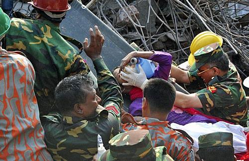 Equipe de resgate auxilia retirada da sobrevivente após 17 dias sob os escombros do prédio desmoronado, em Bangladesh