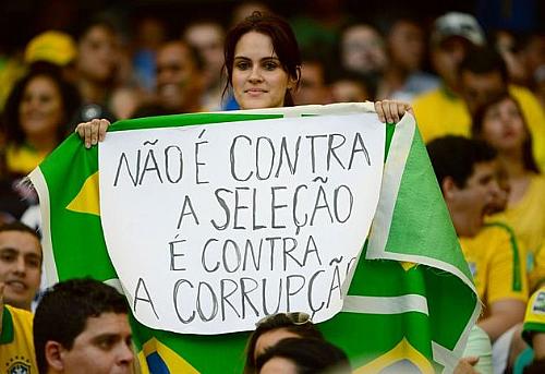 Manifestante segura cartaz durante partida Brasil vs Itália