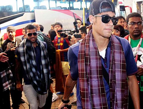 Neymar chega com Daniel Alves: ambos com o manto ao redor do pescoço