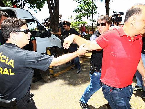 Agente da PF impede que Marcos Valério siga antes de outros condenados no julgamento do mensalão ao chegarem ao IML, em Belo Horizonte
