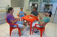 Grupo de amigos levou mesa, cadeiras e baralho para o ar condicionado da agência bancária em Fagundes Varela, no Rio Grande do Sul