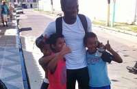 Jogador da Seleção de Gana, Muntari posa com crianças pobres da comunidade do entorno do Trapiche da Barra: atleta disse que localidade lembra onde ele vive (