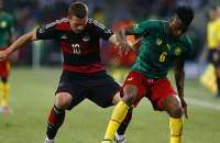 O alemão Lukas Podolski disputa a bola com o camaronês Alexandre Song. A partida terminou dois a dois