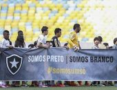 Os jogadores de Botafogo e Santos exibem faixa contra o racismo