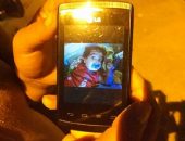 Mãe mostra fotos do filho no aparelho celular