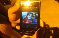 Mãe mostra fotos do filho no aparelho celular