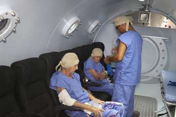 Técnico acompanha pacientes em sessão na câmara hiperbárica