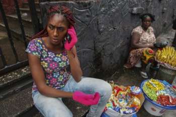 Vendedora de rua na Libéria usa luvas protetoras na tentativa dr prevenir infecção pelo vírus Ebola
