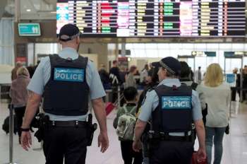 Australia Federal Police officers patrol the security lines at Sydney's Domestic Airport in Australia