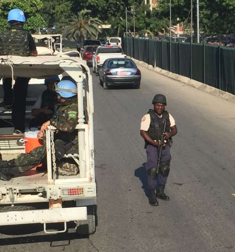 Policial haitiano ao lado de caminhão das forças de paz em seu último dia de patrulha em Porto Príncipe 