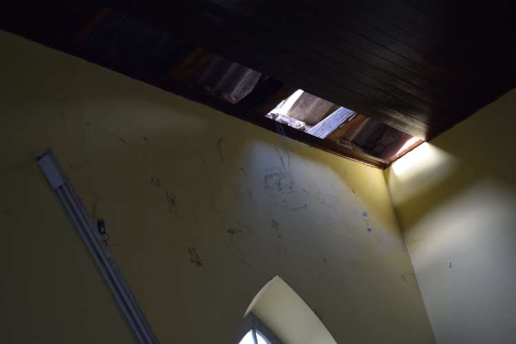 O bandido danificou a cobertura de madeira do teto do salão paroquial para entrar na igreja.