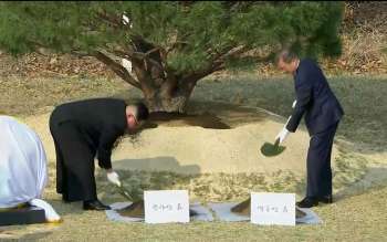 O presidente sul-coreano Moon Jae-in e o líder norte-coreano Kim Jong-un participação de cerimônia em que plantam árvore na aldeia de Panmunjom